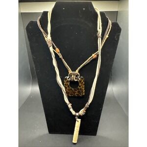 2 Brown And White Necklaces One Plastic And One Bone Pendant -